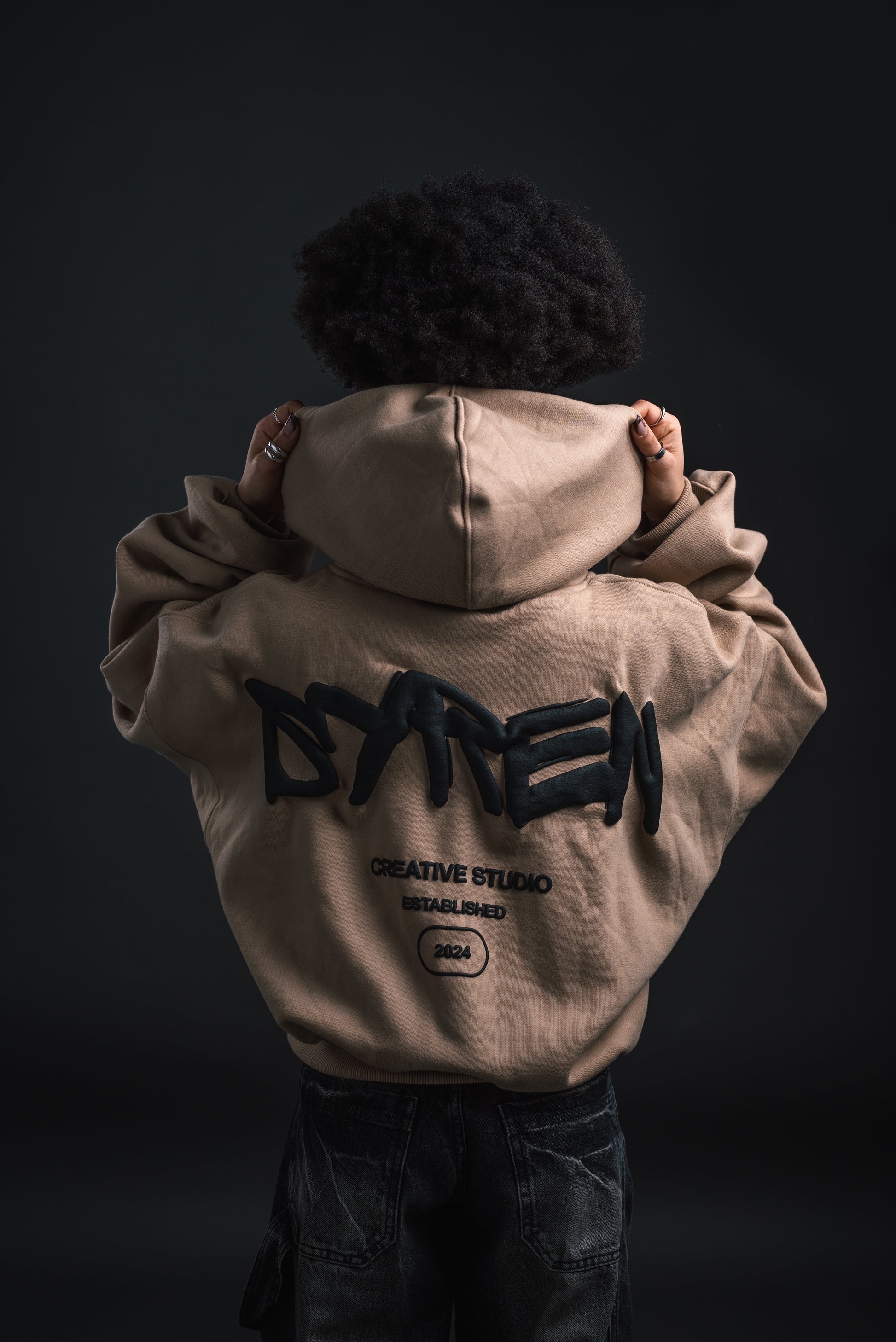 Straight front view of SYREN hoodie worn with hood up – female model
