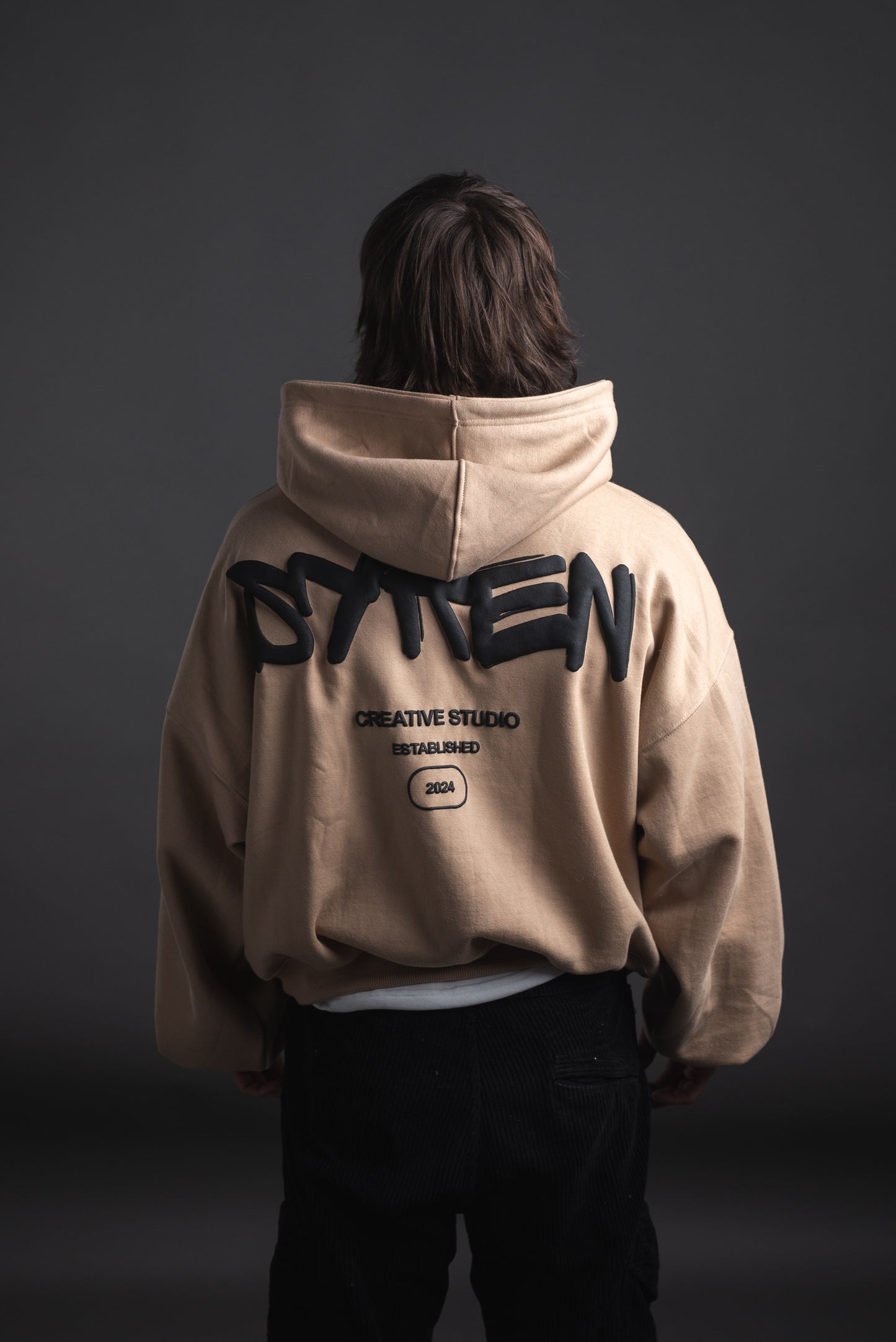 Back view of male model wearing SYREN baggy hoodie showing puff design