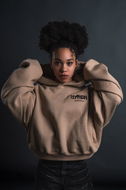 Female model adjusting hood on SYREN 1.0 hoodie – pose with hood.