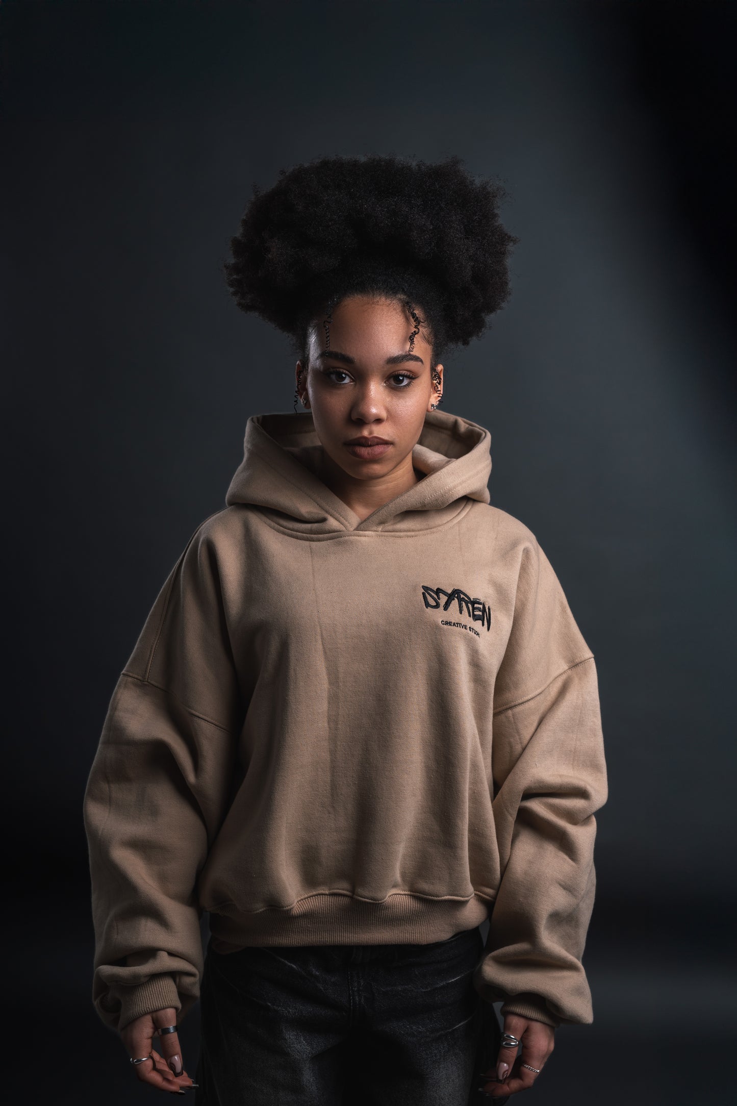 Front view of female model wearing SYREN 1.0 oversized hoodie in beige.